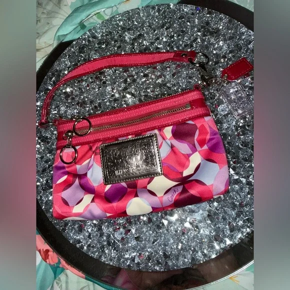 Coach Poppy Wristlet featuring a pink and purple geometric pattern. - Picture 1 of 9